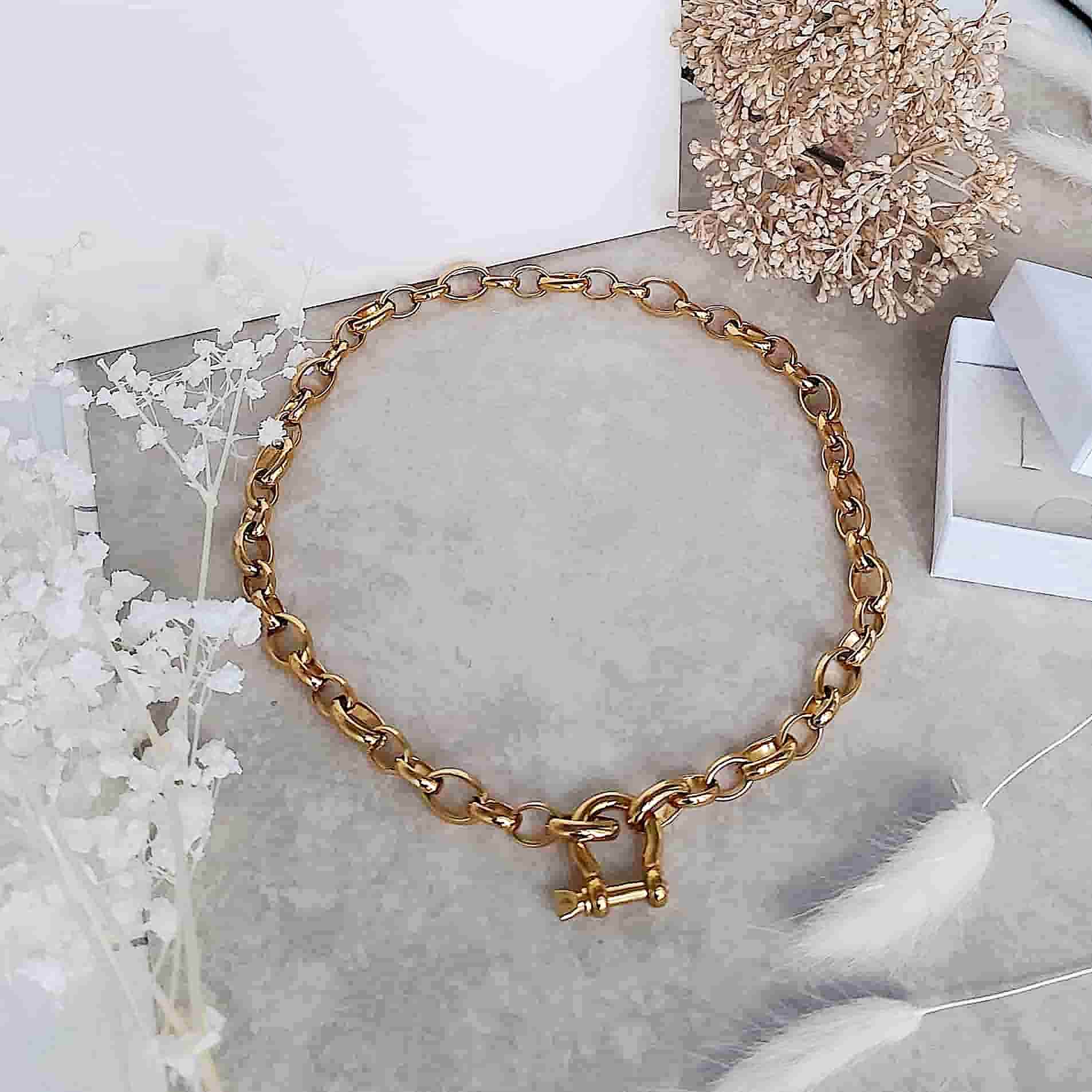 Bracelet grosse maille en acier inoxydable argenté à fermoir manille porté sur un modèle