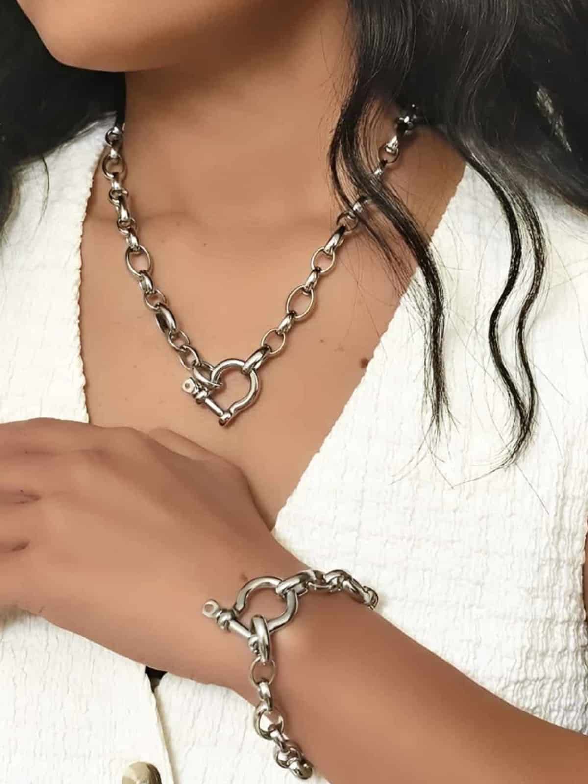 Bracelet grosse maille en acier inoxydable argenté à fermoir manille porté sur un modèle