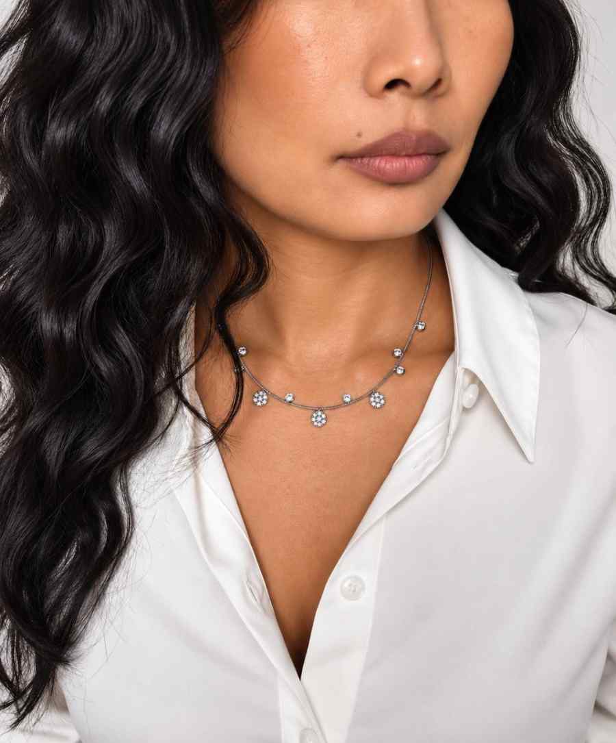 Collier ras de cou en acier inoxydable fin, dorés avec de petits pendentifs alternés  porté sur un modèle