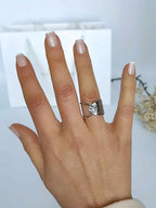Bague en acier inoxydable argenté, ajourée d'un coté et martelée de l'autre portée au doigt