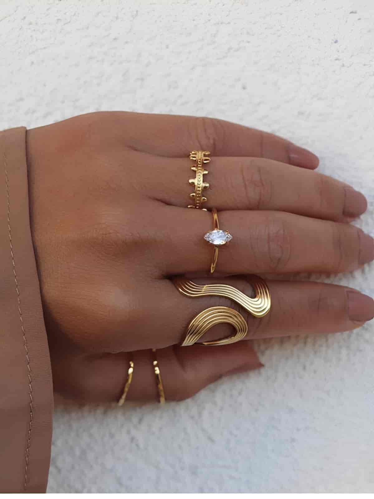 Bagues en acier inxydable ajourés  sur les côtés et striées de couleur doré portée