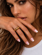 Bague striée en acier inoxydable doré pour femme, au design original et à la finition texturée portée