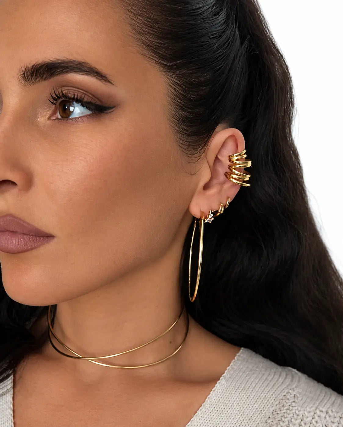 Boucle d’oreille dorée à plusieurs anneaux lisses superposés. portée à l'oreille