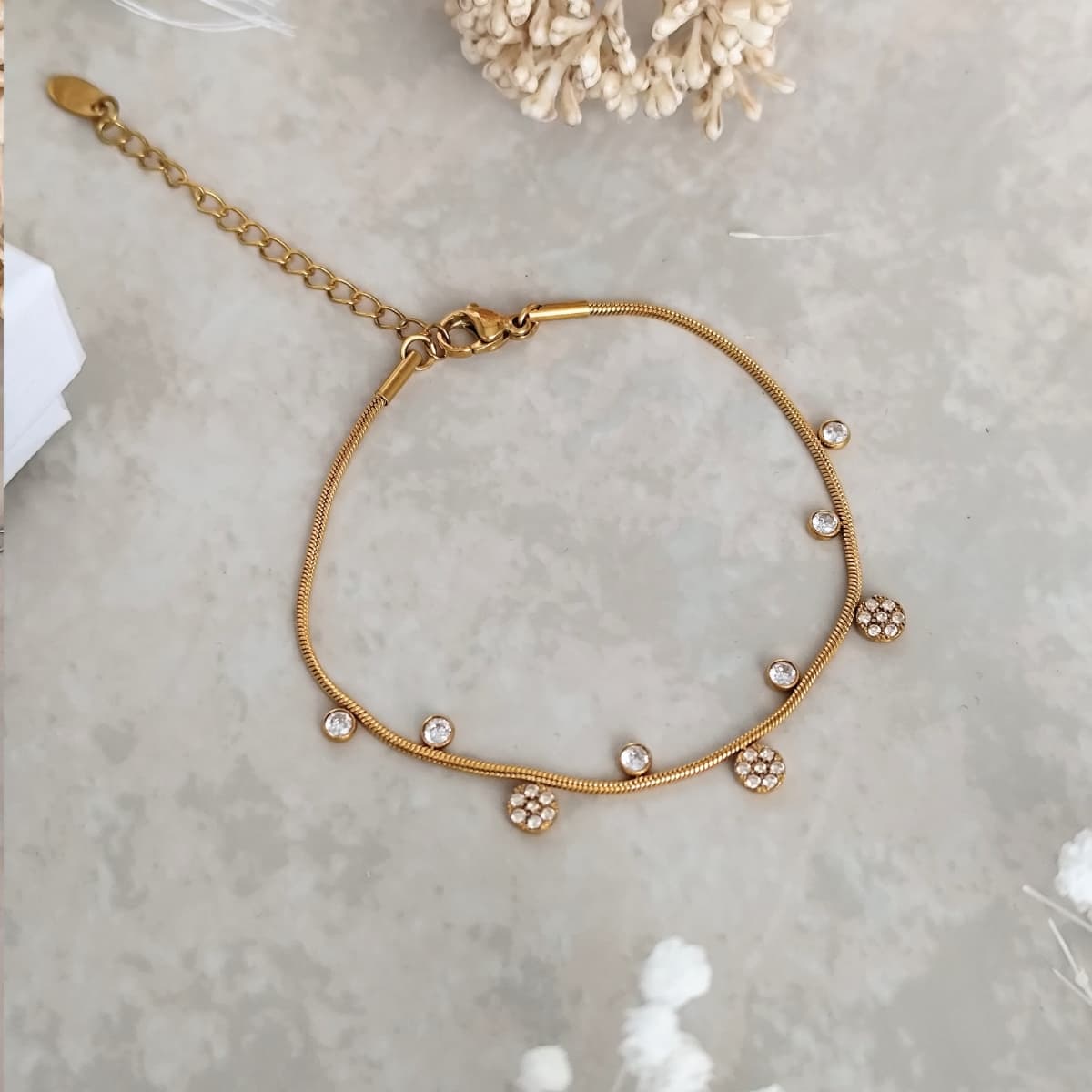 Bracelet en acier inoxydable fin, dorés avec de petits pendentifs alternés 