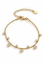 Bracelet en acier inoxydable fin, dorés avec de petits pendentifs en zircons et forme de fleur
