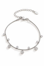 Bracelet en acier inoxydable fin, argentéavec de petits pendentifs en zircons et forme de fleur