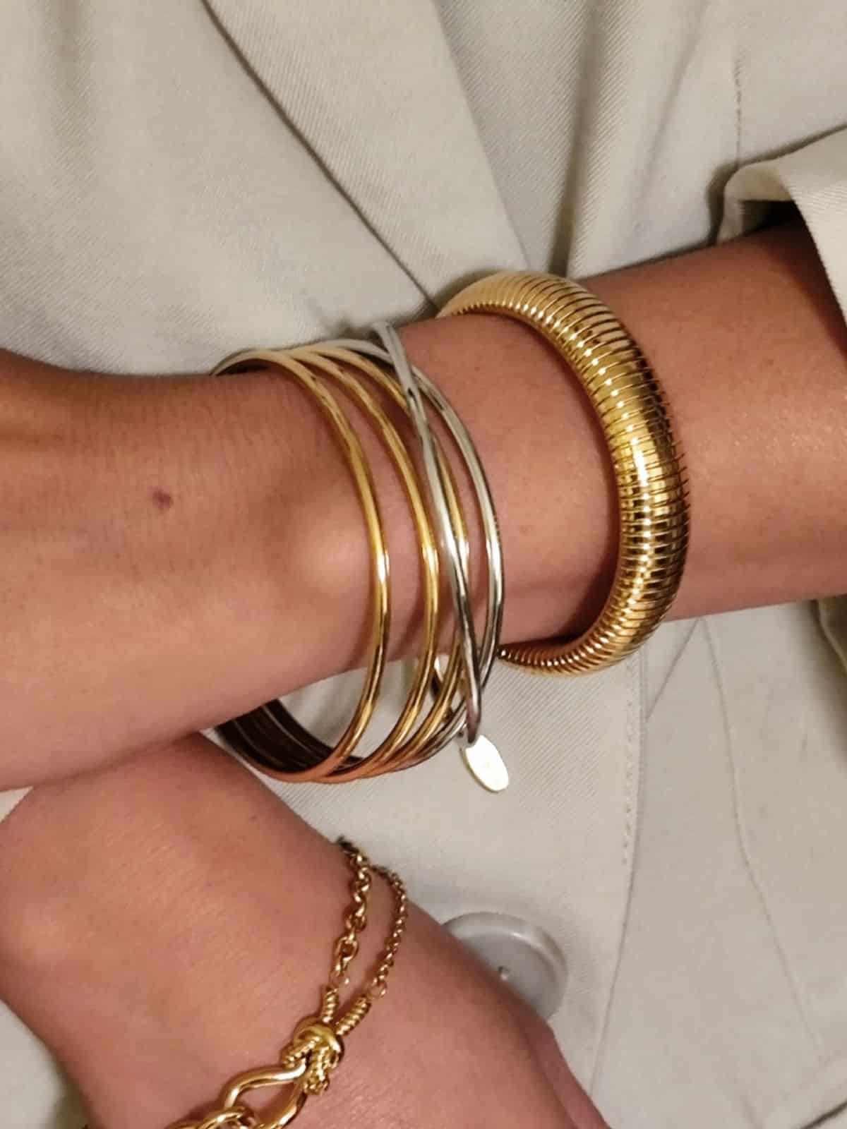 Ensemble de trois joncs fins bi-colors  doré argenté joints par des petits anneaux et pendentif en zircon portés sur le poignet