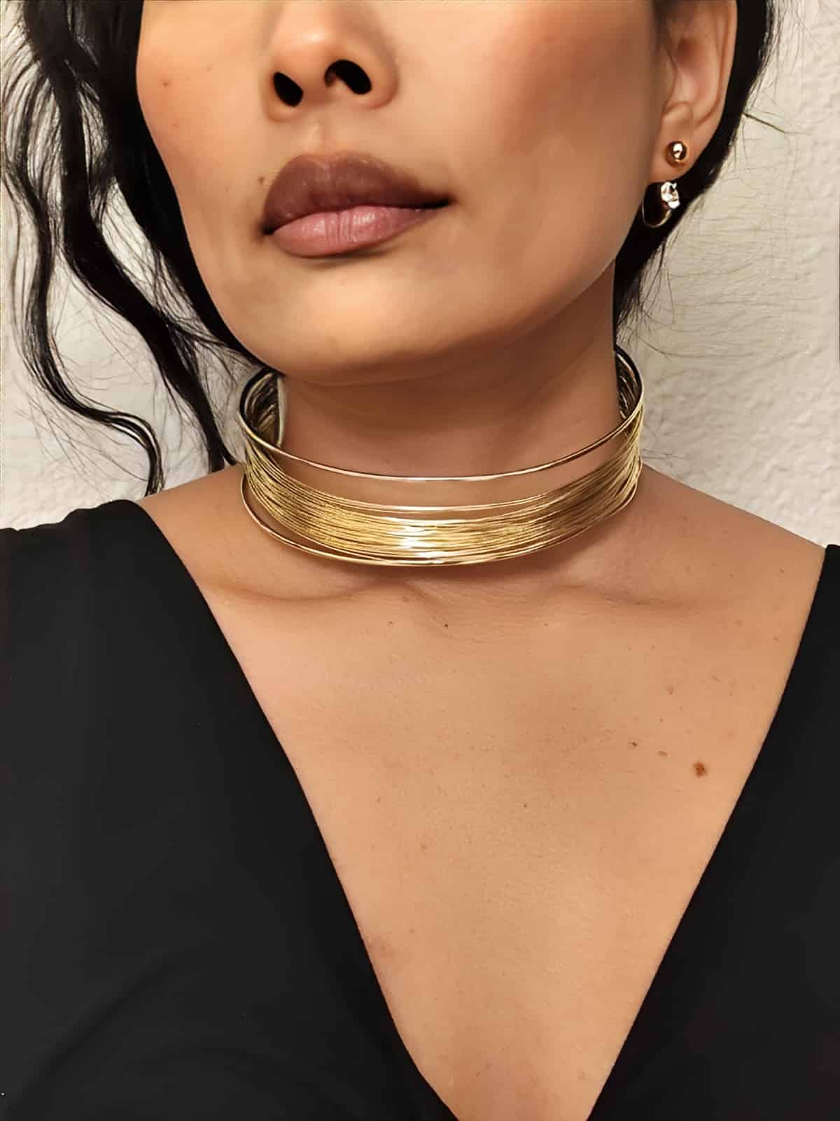 collier ras de cou en acier inoxydable doré fait de spirales  fines superposées porté sur un modèle 