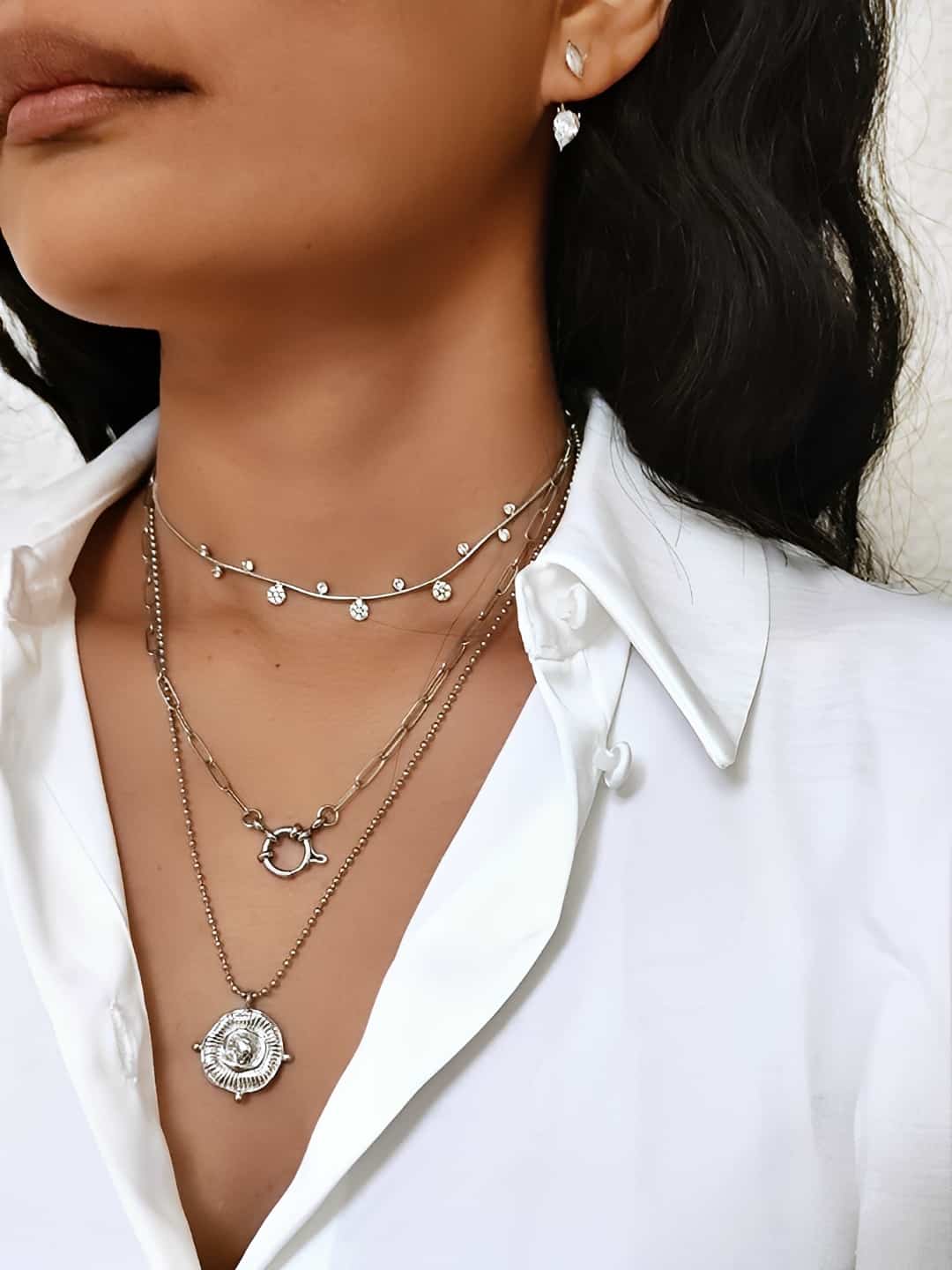 Collier pendentif en acier inoxydable martelés style ethnique argenté en forme de rond et chaîne  à petites billes porté en accumulation avec d'autres colliers