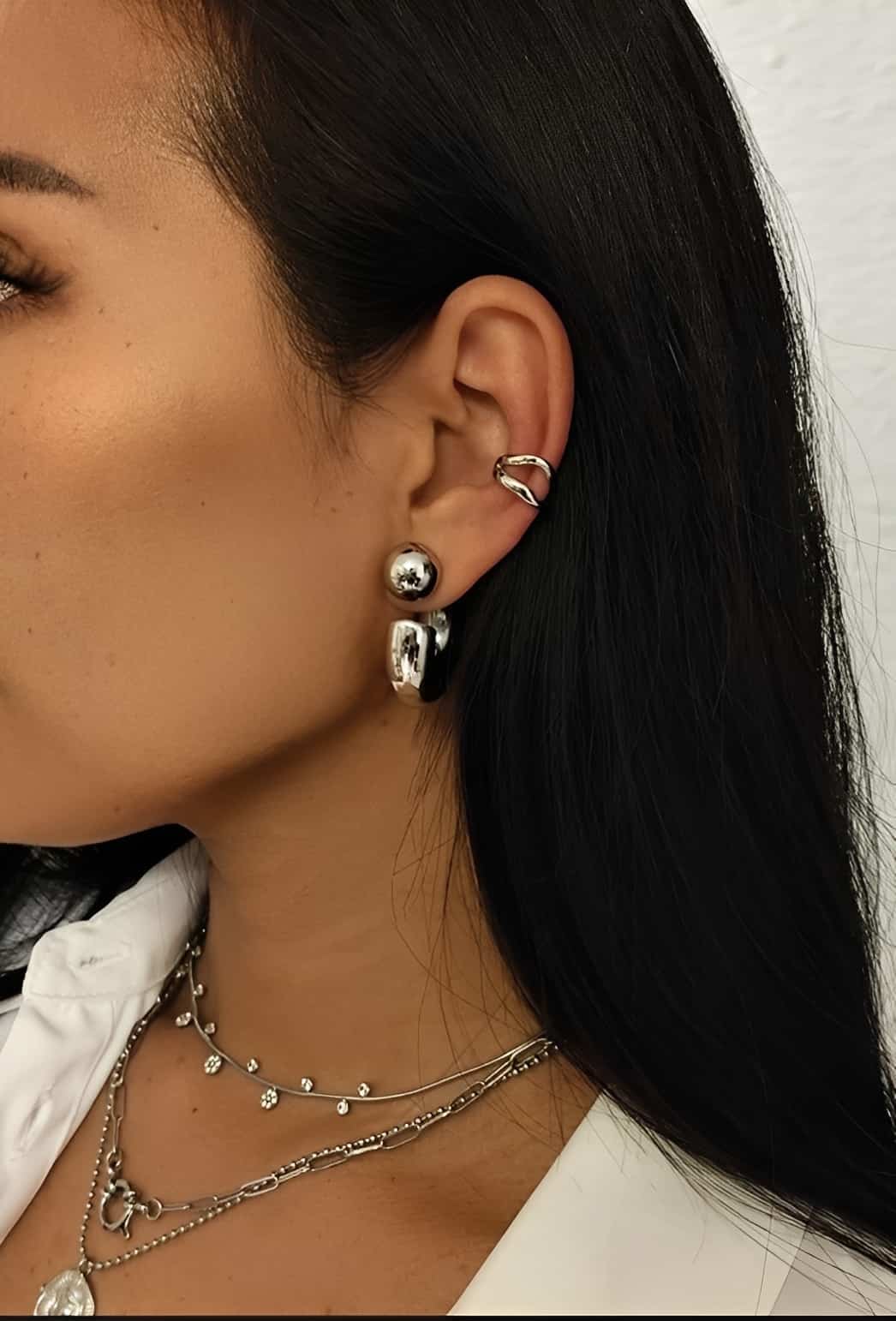 Créoles en acier inoxydable épaisses avec une boule sur le devant argentées portées sur un modèle