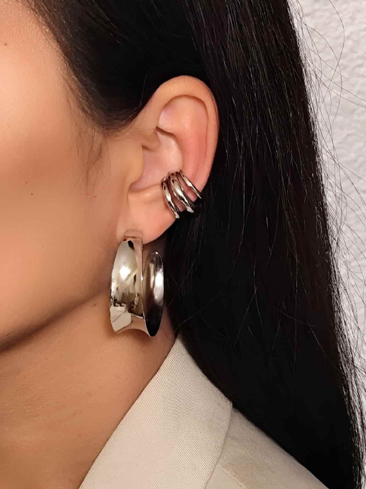  créoles en acier inoxydable larges argentées de forme concave  portées à l'oreille en association avec un earcuff