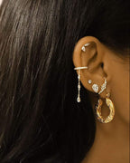Boucles d'oreilles créoles martelées forme hexagone dorées en acier portées en accumulation avec d'autres boucles