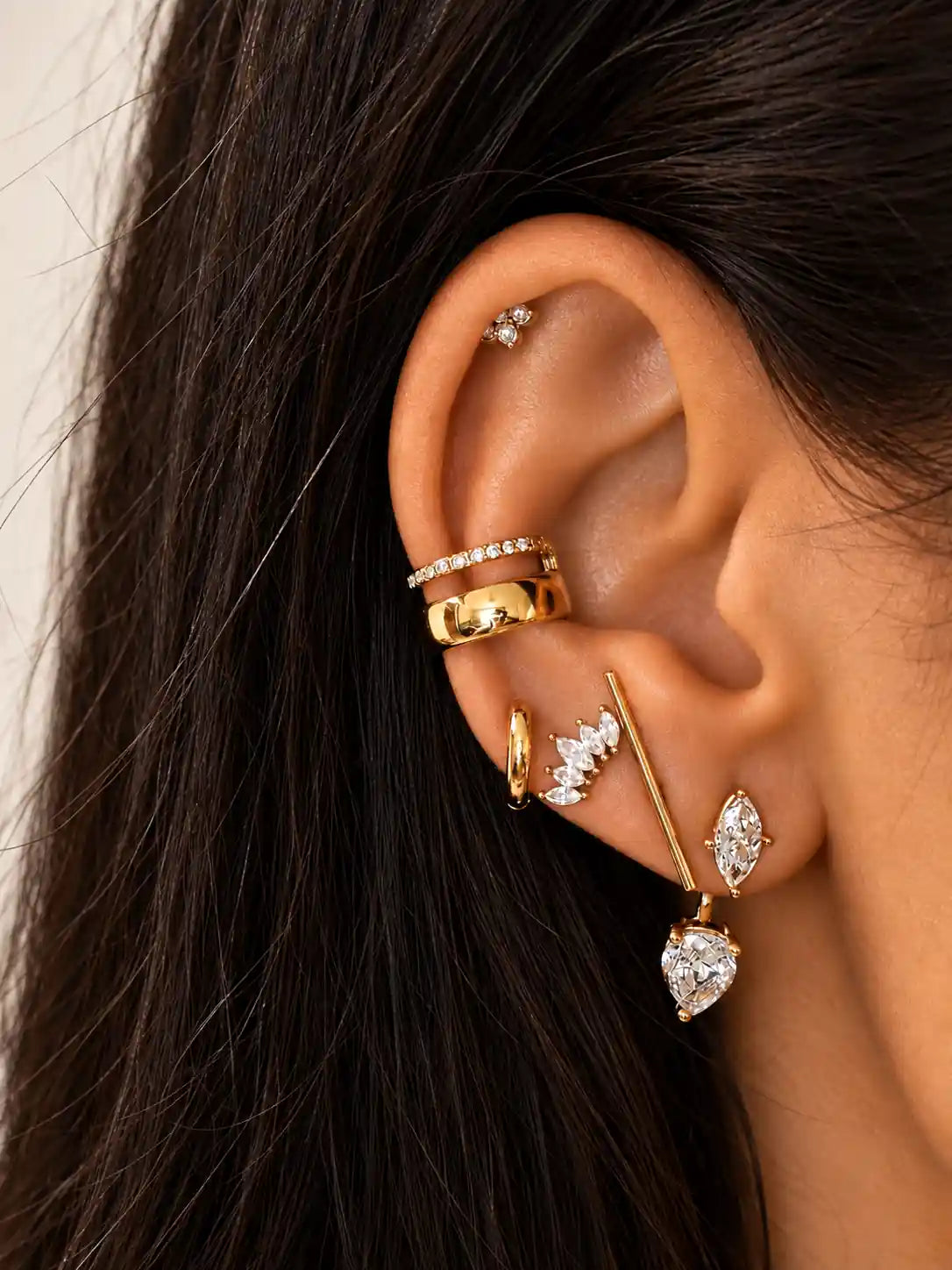 Ear cuff femme doré en acier inoxydable à deux étages avec détails délicats porté en accumulation avec d'autres boucles