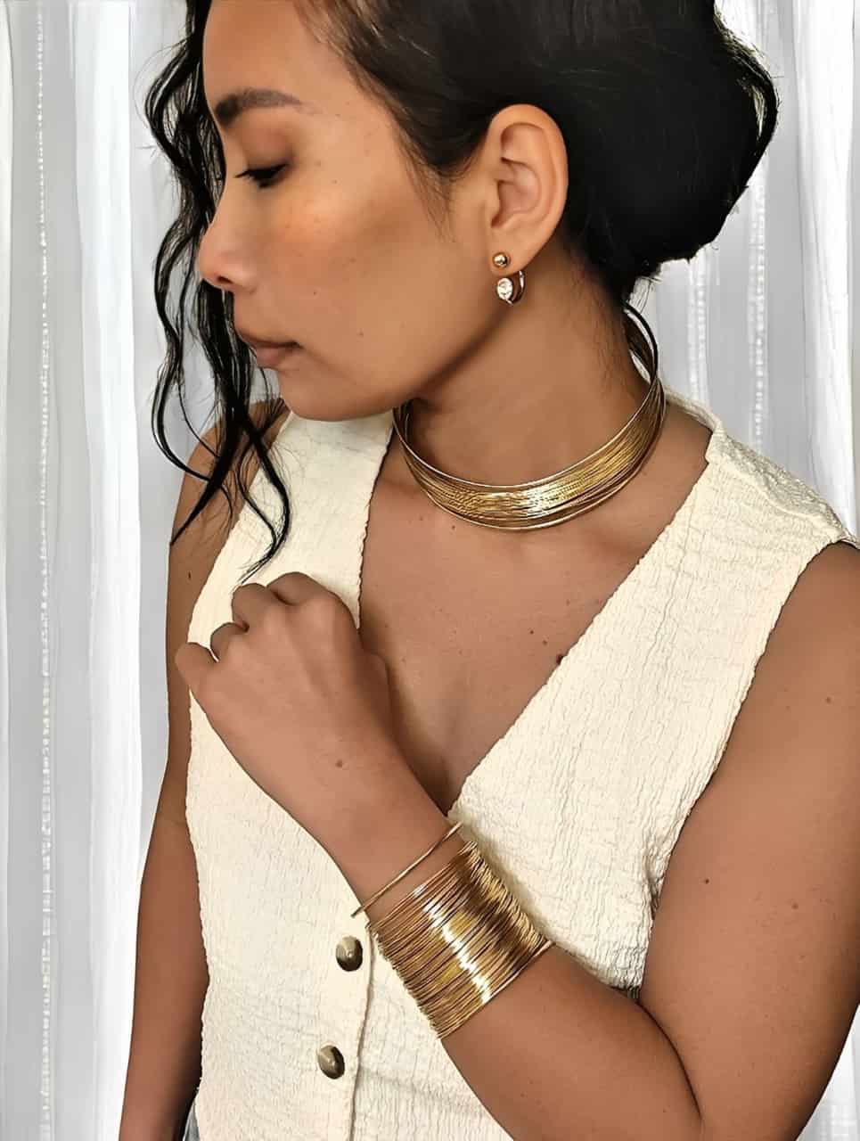 manchette dorée en acier inoxydable  large en forme de spirales portée sur un modèle