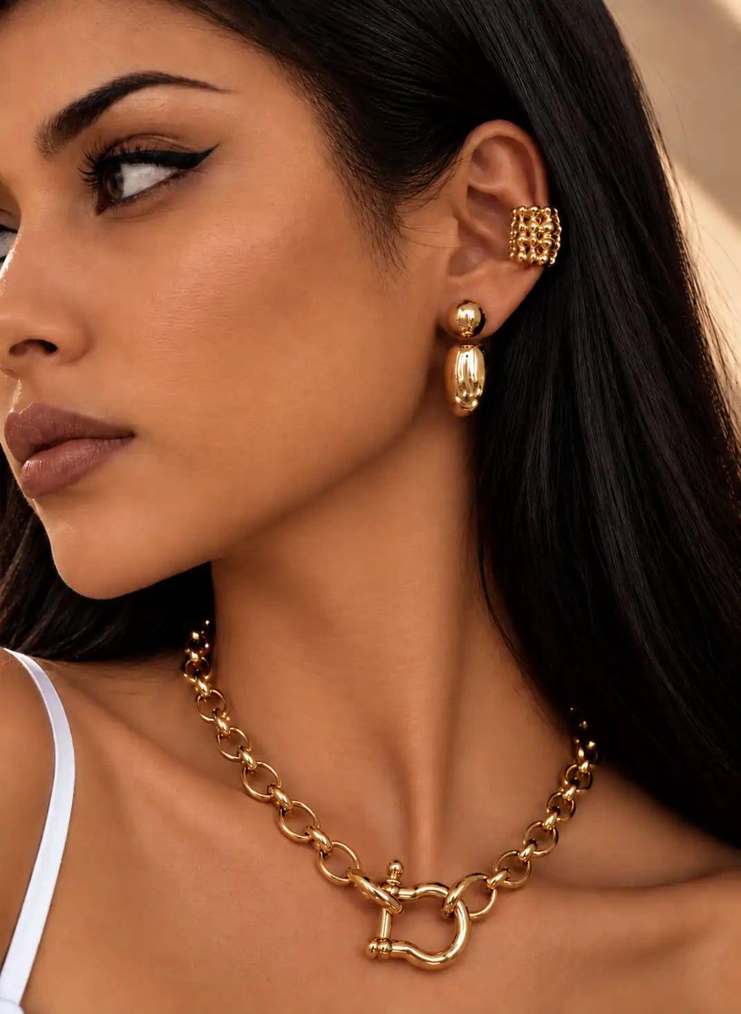 Manchette d’oreille en acier inoxydable  sans piercing  dorée  formée de petites boules assemblées en une manchette haute  en association avec une créole épaisse au lobe portée