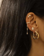 Puces d'oreilles en forme de gouttes serties de Zircons en acier inoxydable doré portées en accumulation sur une oreille