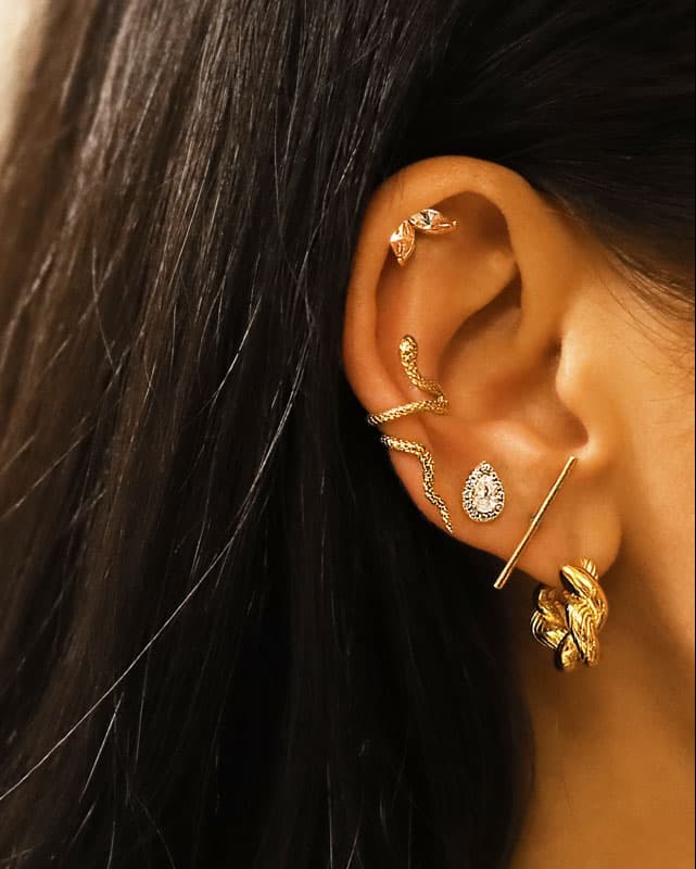 Puces d'oreilles gouttes serties de Zircons en acier inoxydable portées en accumulation sur une oreille