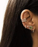 Puces d'oreilles rondes serties d'une Pierre Oeil de Chat verte argentées en acier inoxydable portées en accumulation avec d'autres boucles d'oreilles
